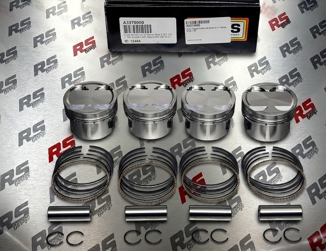 Set of piston rings and pins on a branded background